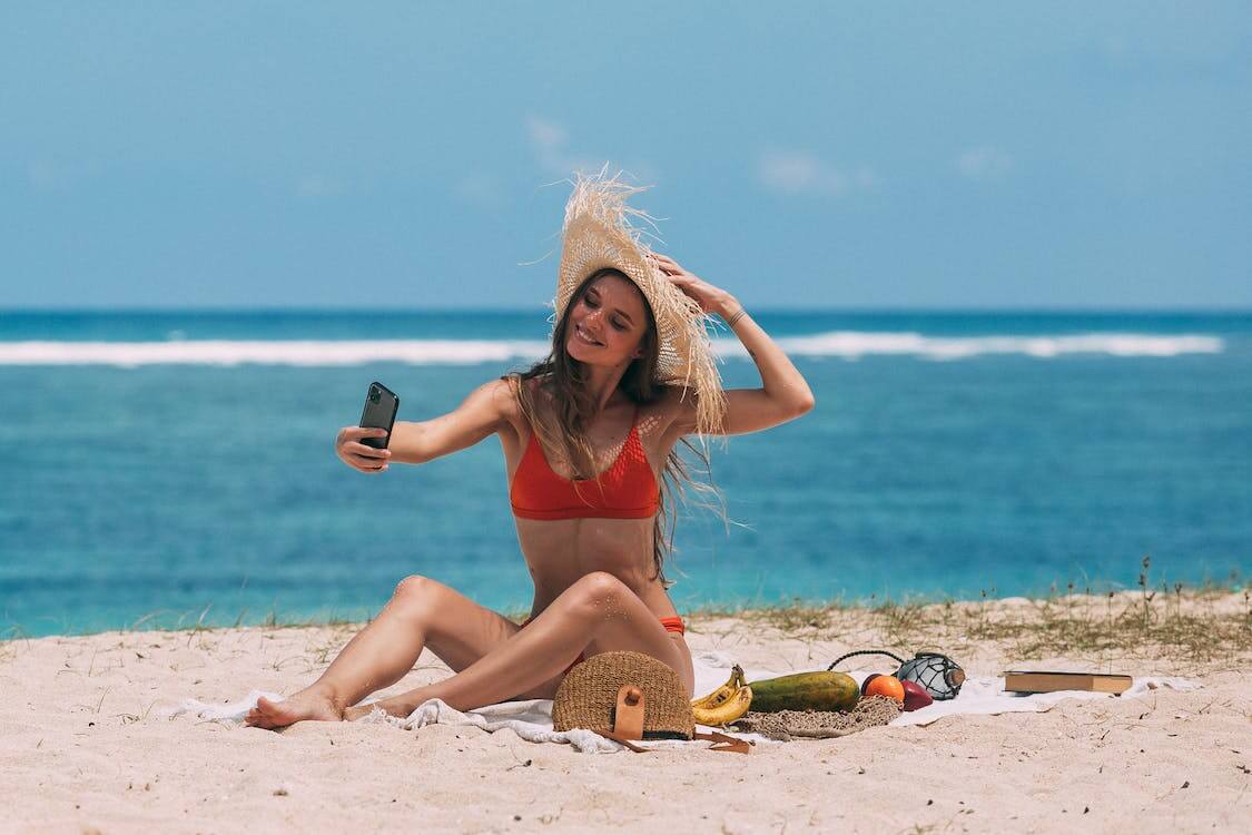 the mermaid pose by sitting on the beach sand