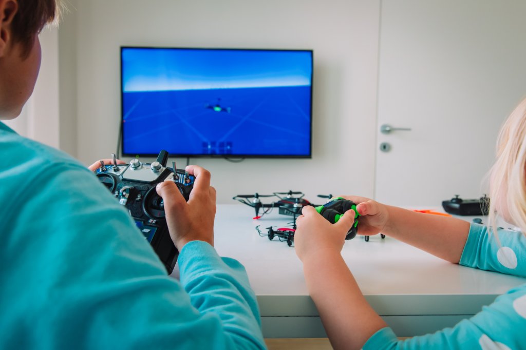 kids learning to pilot on simulator, boy and girl with remote controls in hands